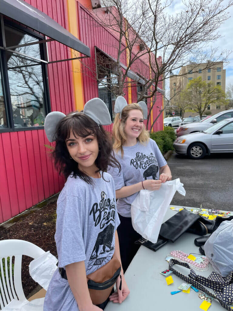 Two Buffalo Exchange employees wearing elephant ears and Buffalo Exchange t shirts