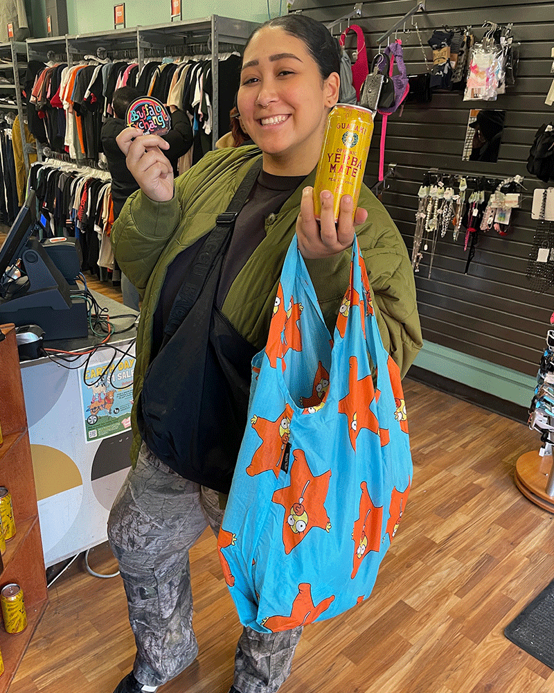 person holding a sticker, bag, and drink can