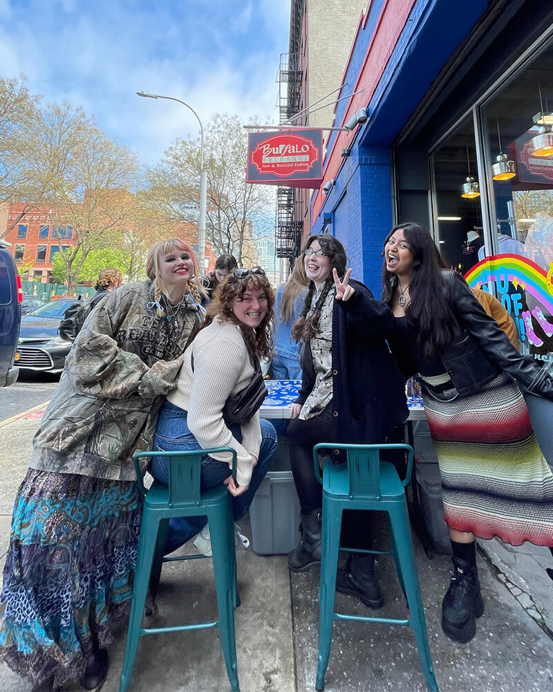 group of persons posing in front of store