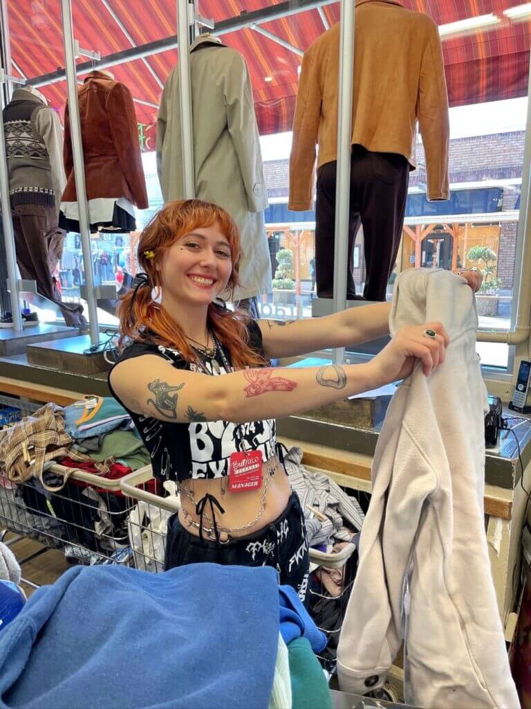 Buffalo Exchange employee holding up an article of clothing