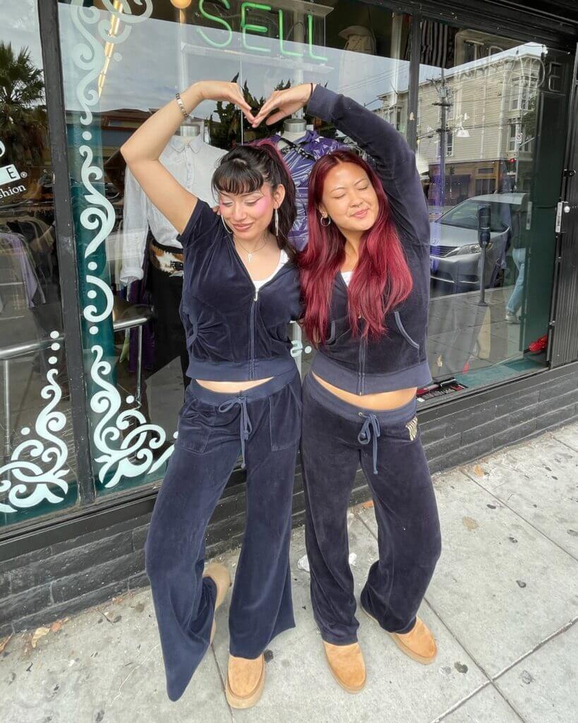 two Buffalo Exchange employees posing in blue tracksuits