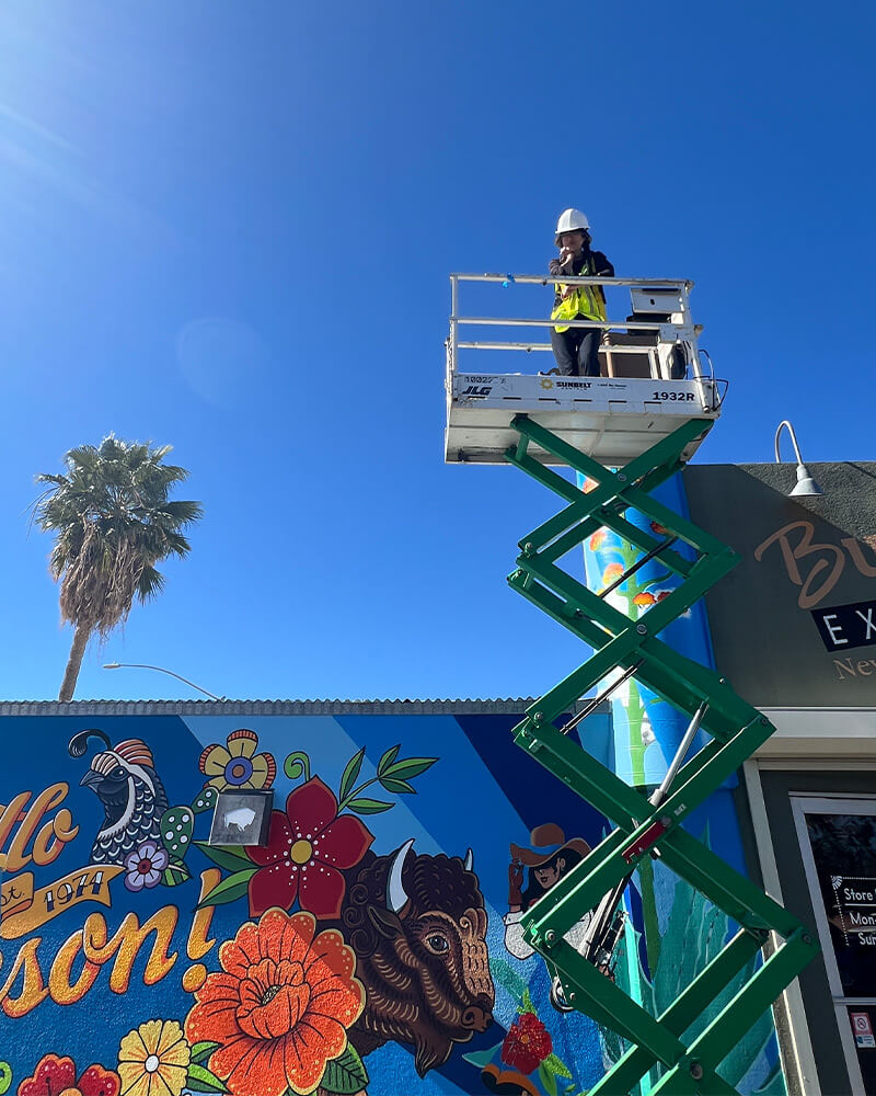 katie on the lift painting the mural