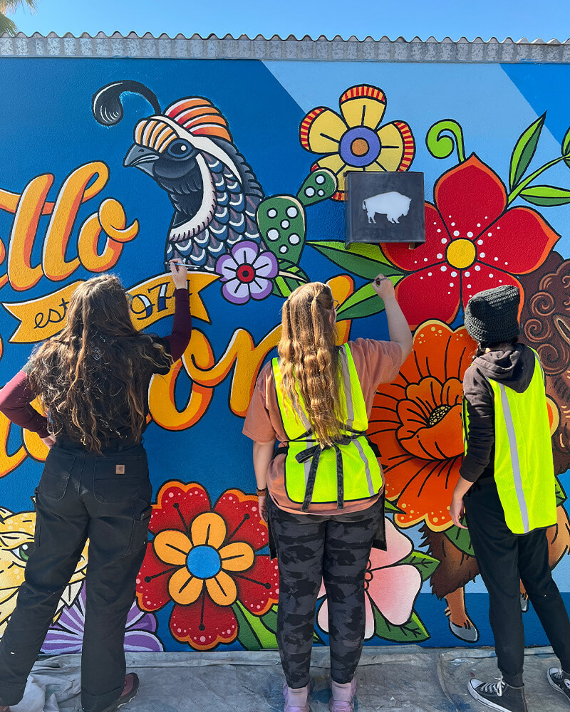 emma, quinn, and katie painting the mural