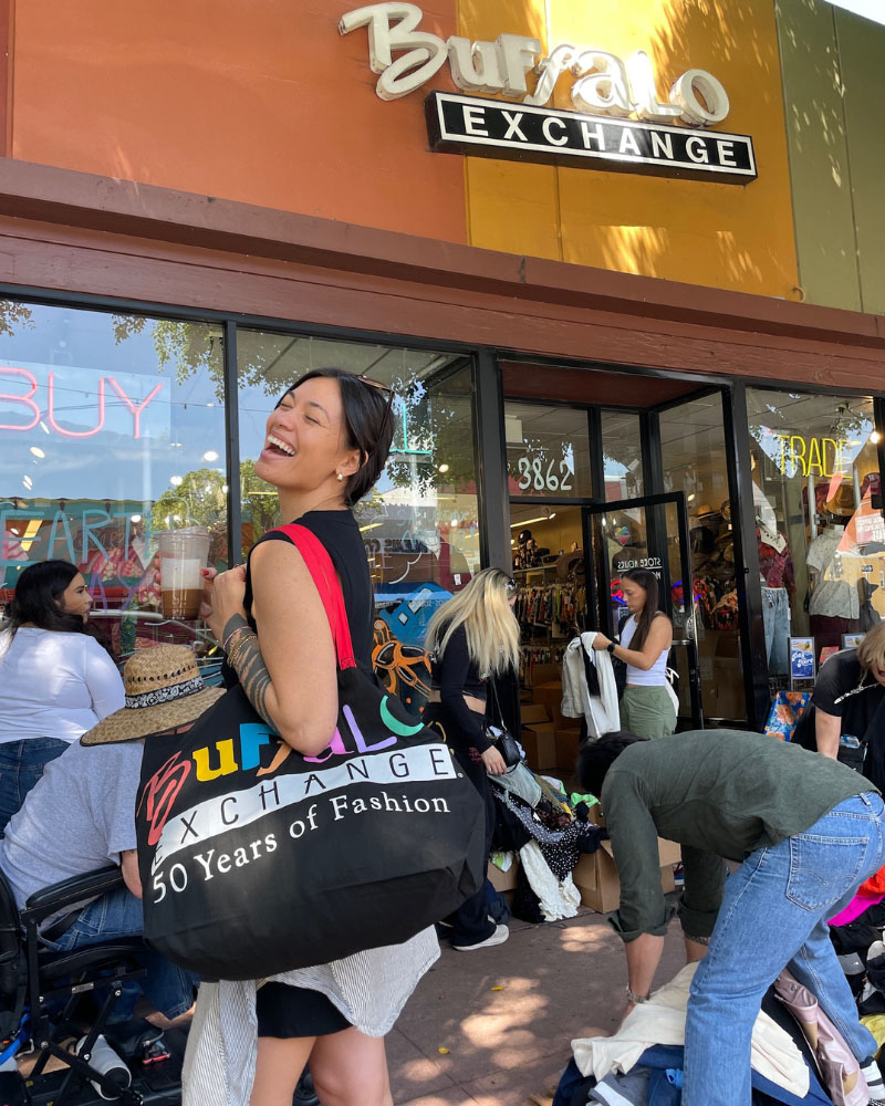 Customer at the $1 Sale smiling and holding a Buffalo tote full of clothes